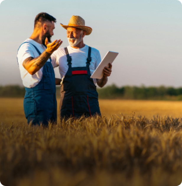 Two farmers reviewing irrigation plans in a field